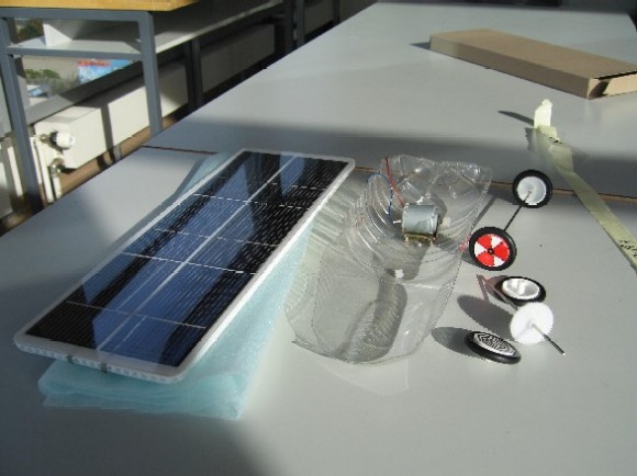 un panneau solaire, une demi-bouteille en pet et des roues
